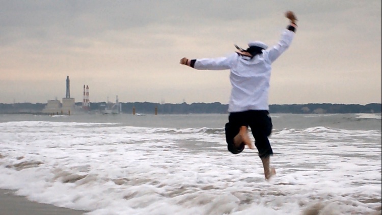 Michael springt in Band-Uniform ins Meer am Strand von Nakoso in Fukushima, Japan.
